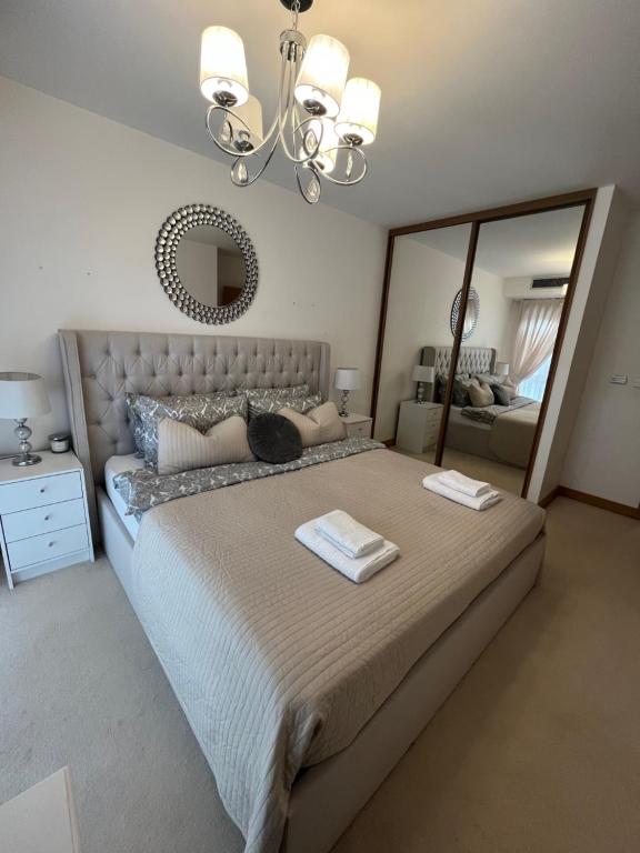 a bedroom with a large bed with a large mirror at Two double bedroom duplex flat in London