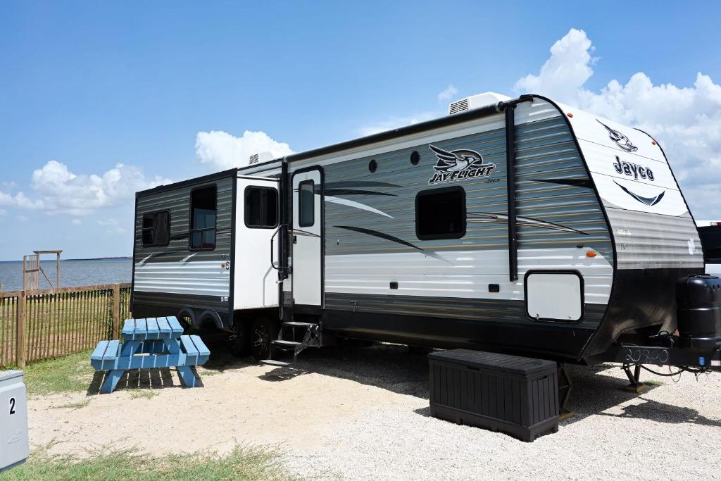 an rv parked on the sand near the ocean at Bay View Glamping in Bolivar Peninsula