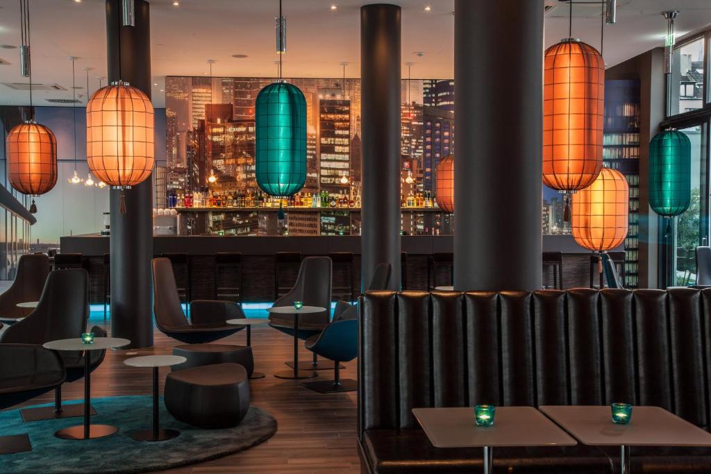 ein Restaurant mit Blick auf die Skyline der Stadt in der Unterkunft Motel One Düsseldorf Hauptbahnhof in Düsseldorf