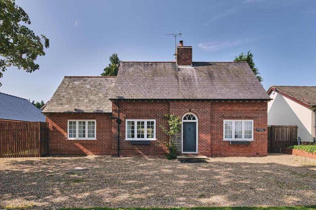 a red brick house with a black door at Steward's Cottage 