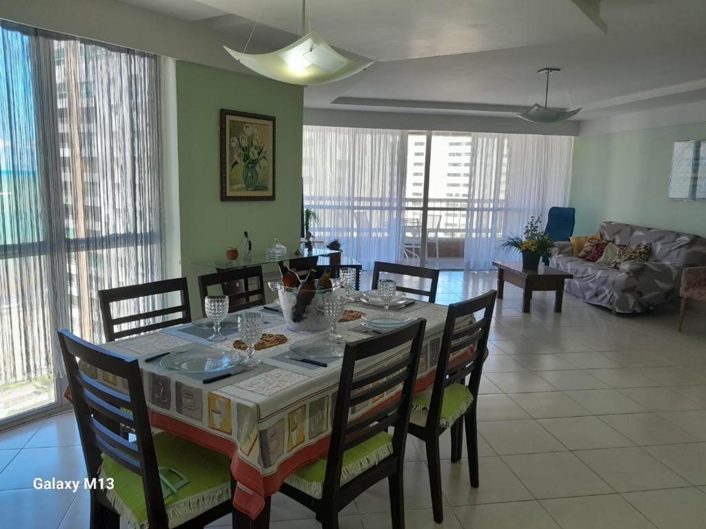 comedor y sala de estar con mesa y sillas en Praia de Piedade, en Recife