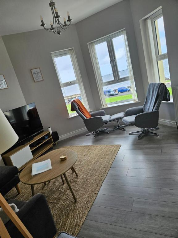 a living room with chairs and a table at Saltwater Edge Apartment in Portrush