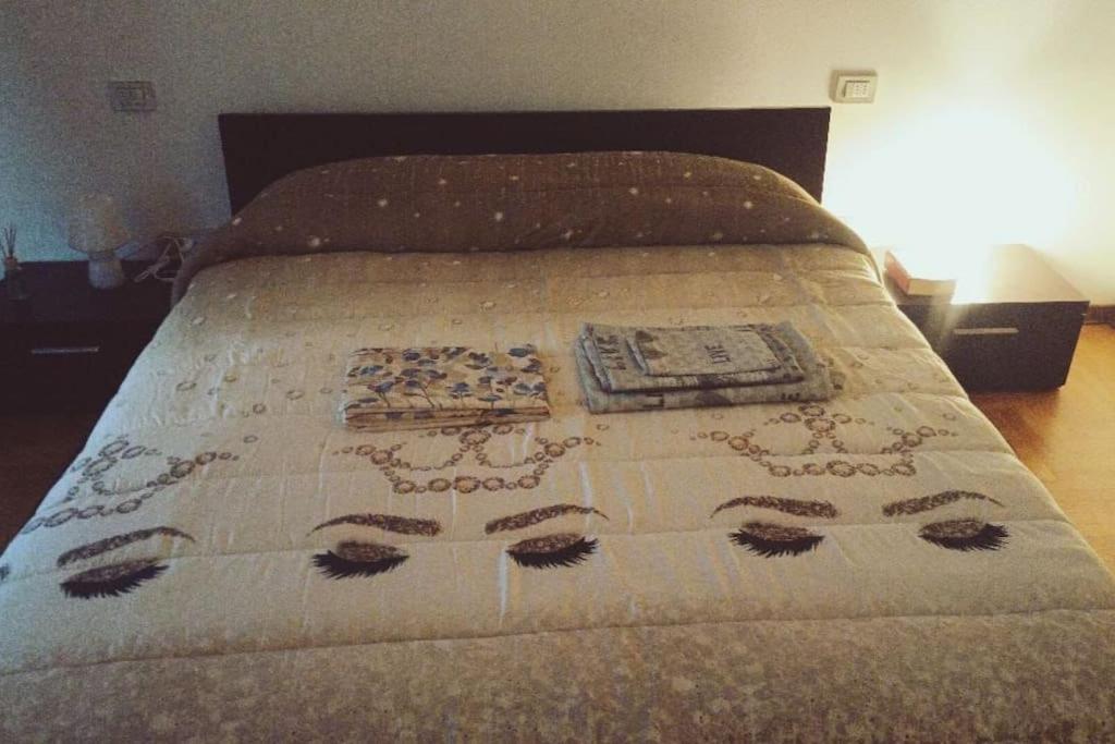 a bed with a comforter with a pattern on it at Seveso Centro stazione , 15 minuti da Milano in Seveso