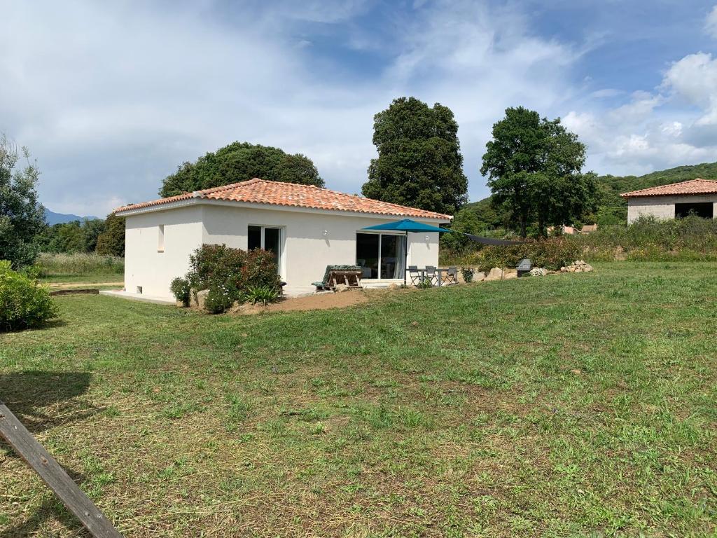 a small white house with a large yard at A PIAZZOLA in Petreto-Bicchisano