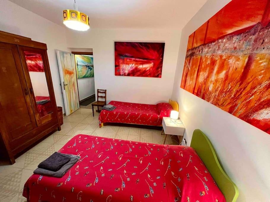 una camera con letto rosso e divano di La casa dell’artista di Vittorio Vertone a Pietragalla