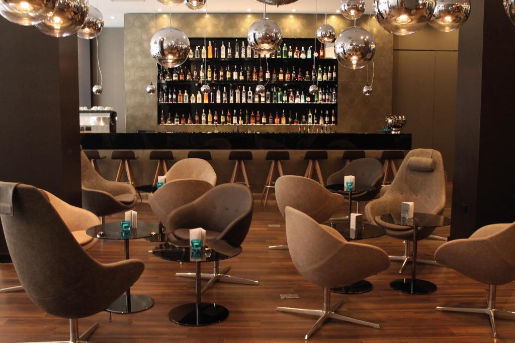 a row of chairs and tables in a room with a bar at Motel One Manchester-Piccadilly in Manchester