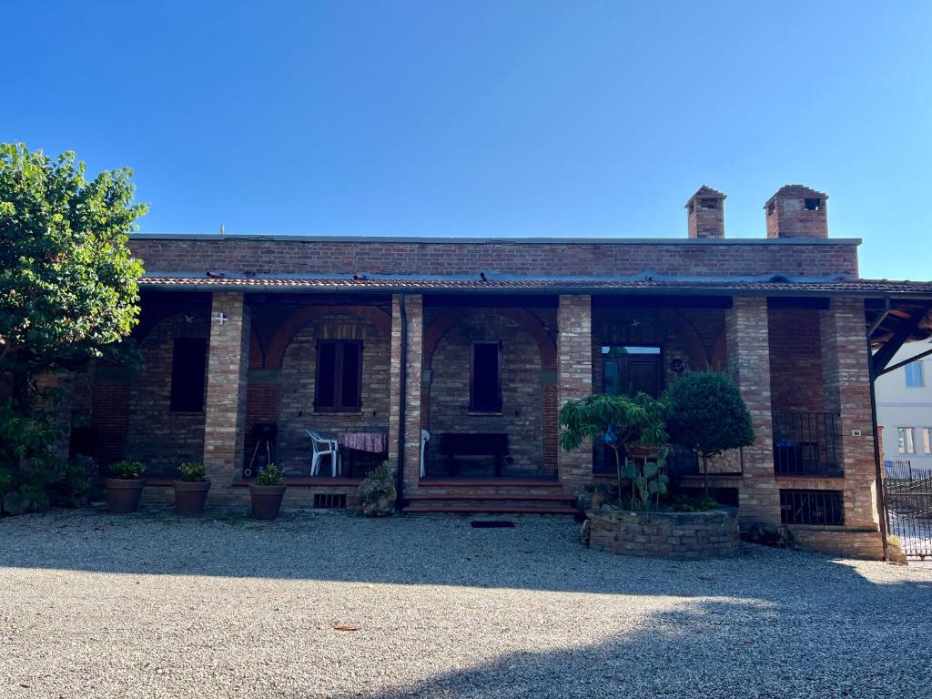 a brick house with a porch and a patio at Casa Isidora in Acquaviva