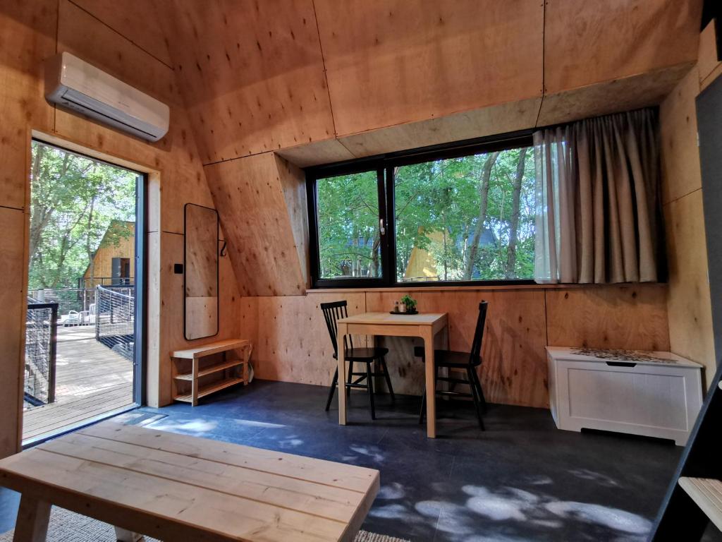 a room with a table and chairs and a window at TREE-TOP VILLAGE, Tokajské domčeky v korunách stromov in Malá Bara