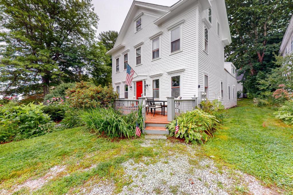 una casa blanca con una puerta roja en Quarters on Main, en Castine