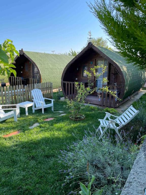 a house with a green roof and two chairs and a house at Nur Konak Bungalov 7 in Çanakkale