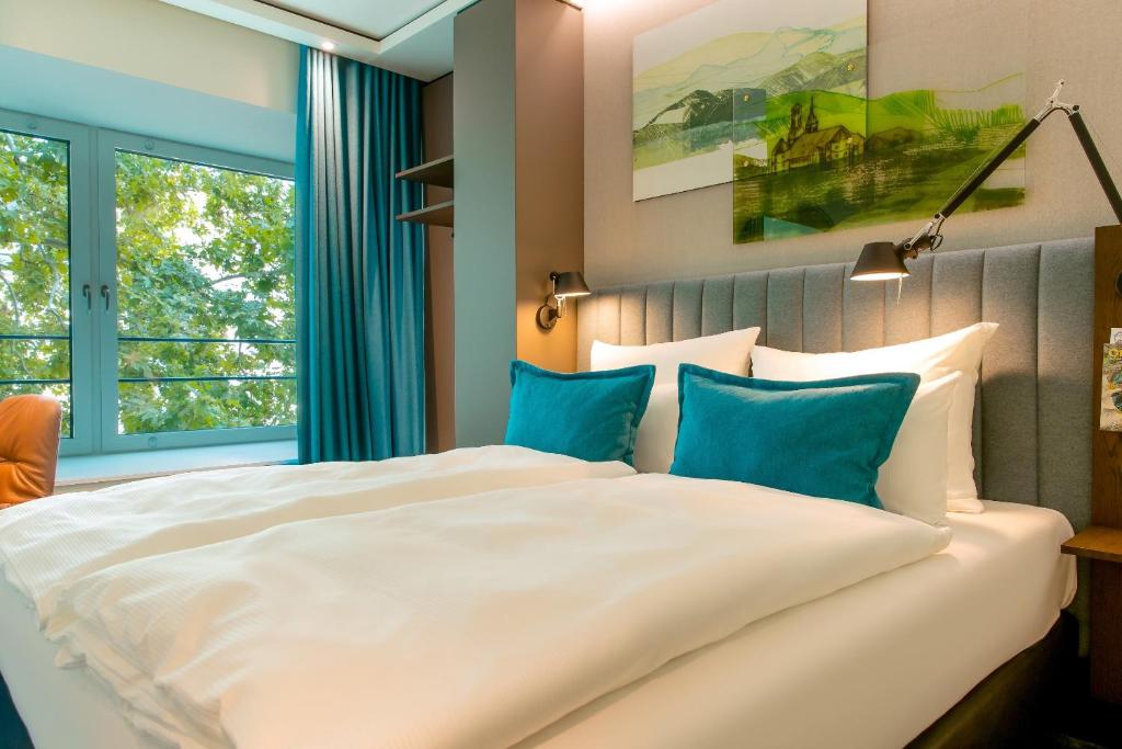 Postel nebo postele na pokoji v ubytování Motel One Stuttgart-Hauptbahnhof