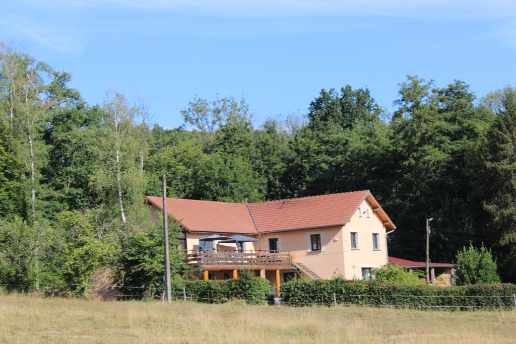 ein Haus mit rotem Dach auf einem Feld in der Unterkunft Chambre d'hôtes Les Cinq Mésanges 
