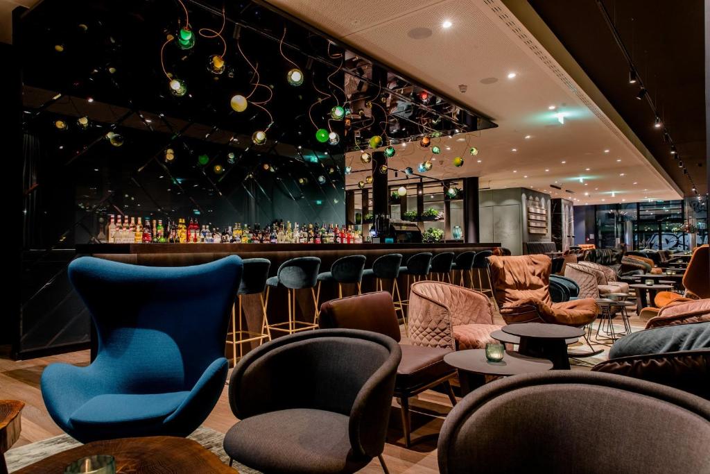 een bar in een restaurant met stoelen en tafels bij Motel One Stuttgart-Hauptbahnhof in Stuttgart