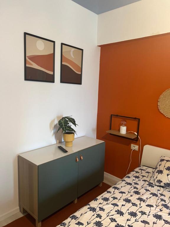 a bedroom with a bed and a cabinet with a plant on it at Casa de la Mare in Mamaia Nord