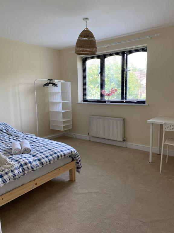 a bedroom with a bed and a table and windows at Oasis in Buckinghamshire