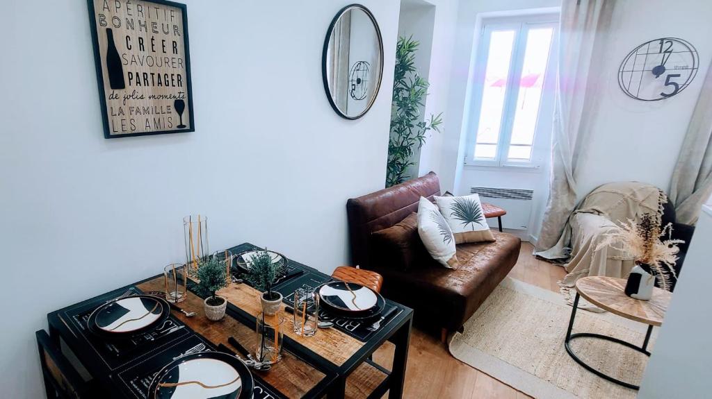 una sala de estar con una mesa y un sofá en 7 couchages aux portes des célèbres Parfumeries WIFI, en Grasse