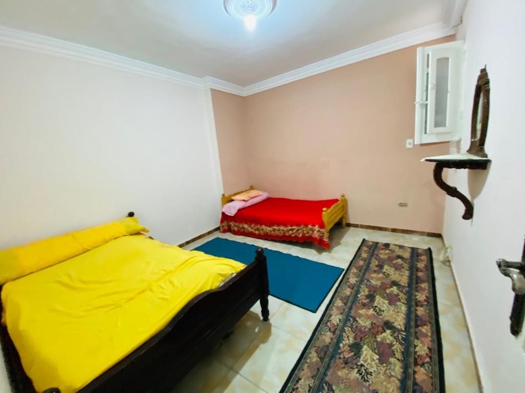 a bedroom with two beds with yellow and red sheets at شقة للايجار اسكندرية in Alexandria