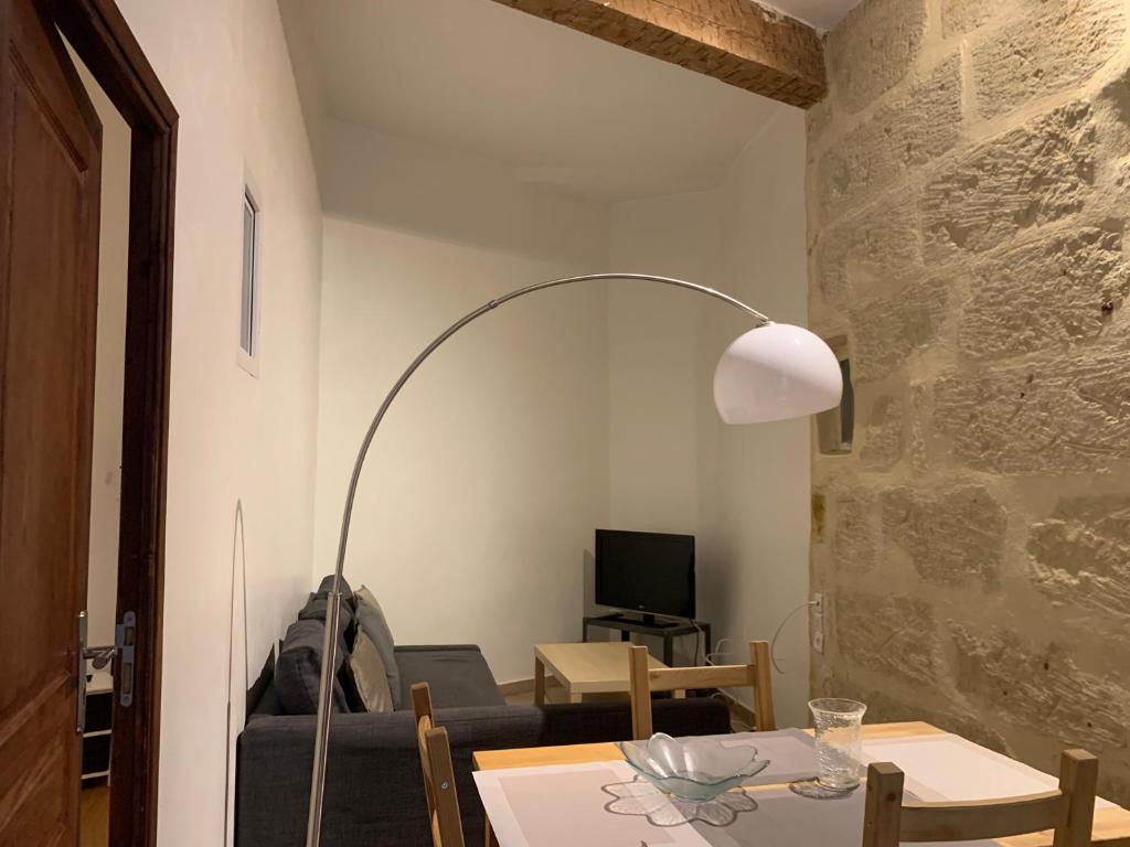 a living room with a table and a floor lamp at Appartement centre historique in Montpellier