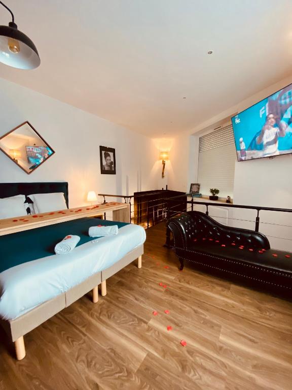 - un salon avec 2 lits et une télévision à écran plat dans l'établissement Mieuxqualhotel jacuzzi privatif La retro, à Bordeaux