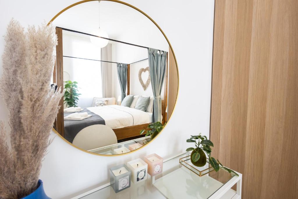 a bedroom with a mirror on a wall with a bed at 10 min walk to Schonbrunn l Deluxe Suite in Vienna