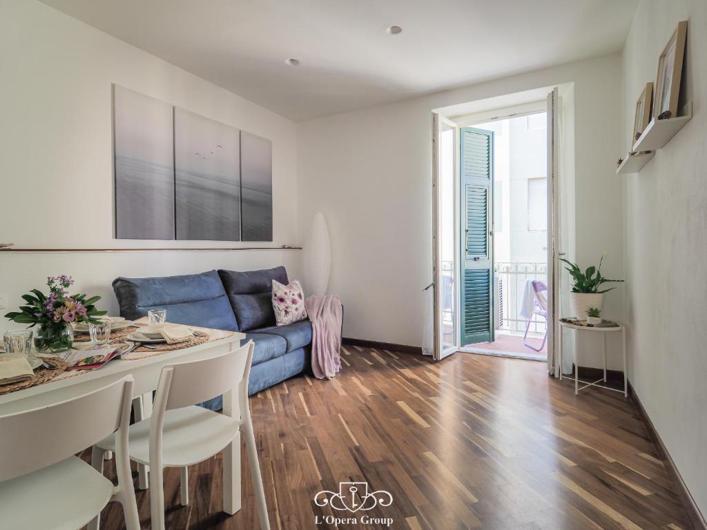 a living room with a blue couch and a table at La Malva - L'Opera Group in La Spezia