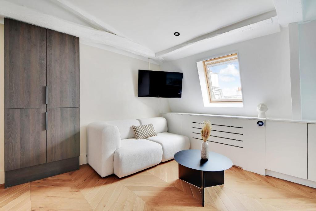a living room with a white couch and a table at Brand New Modern Studio in Central Paris - 2P - B6 in Paris