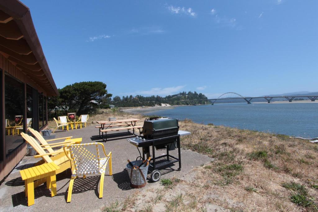 沃德波特的住宿－Bayside，水边的露台上的烧烤架和椅子