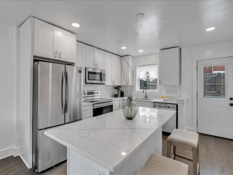 a kitchen with white cabinets and a large white island at Quaint 3/2.5 home in Fort Dupont in Washington, D.C.