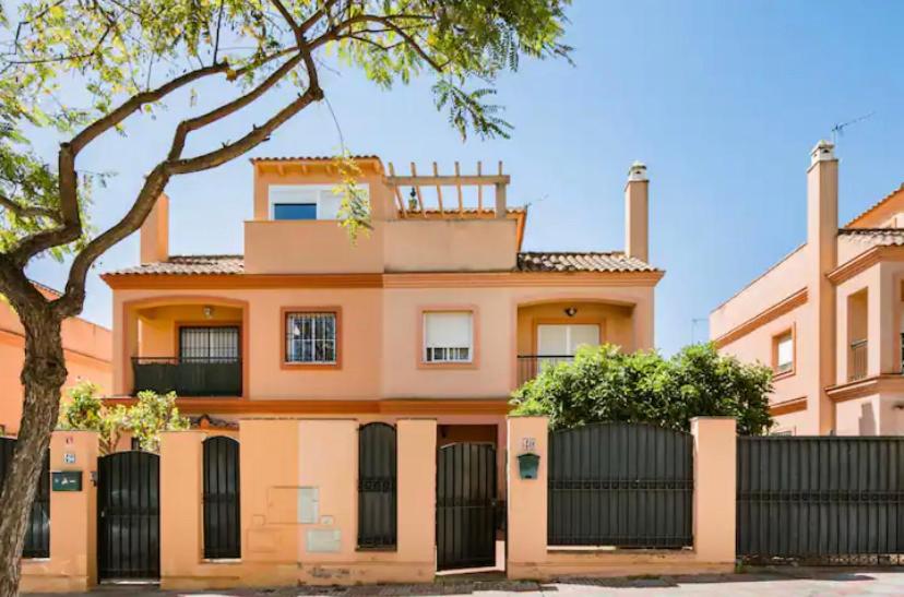 ein orangenes Gebäude mit einem Zaun davor in der Unterkunft 3 La Casa De Marilo in Tomares