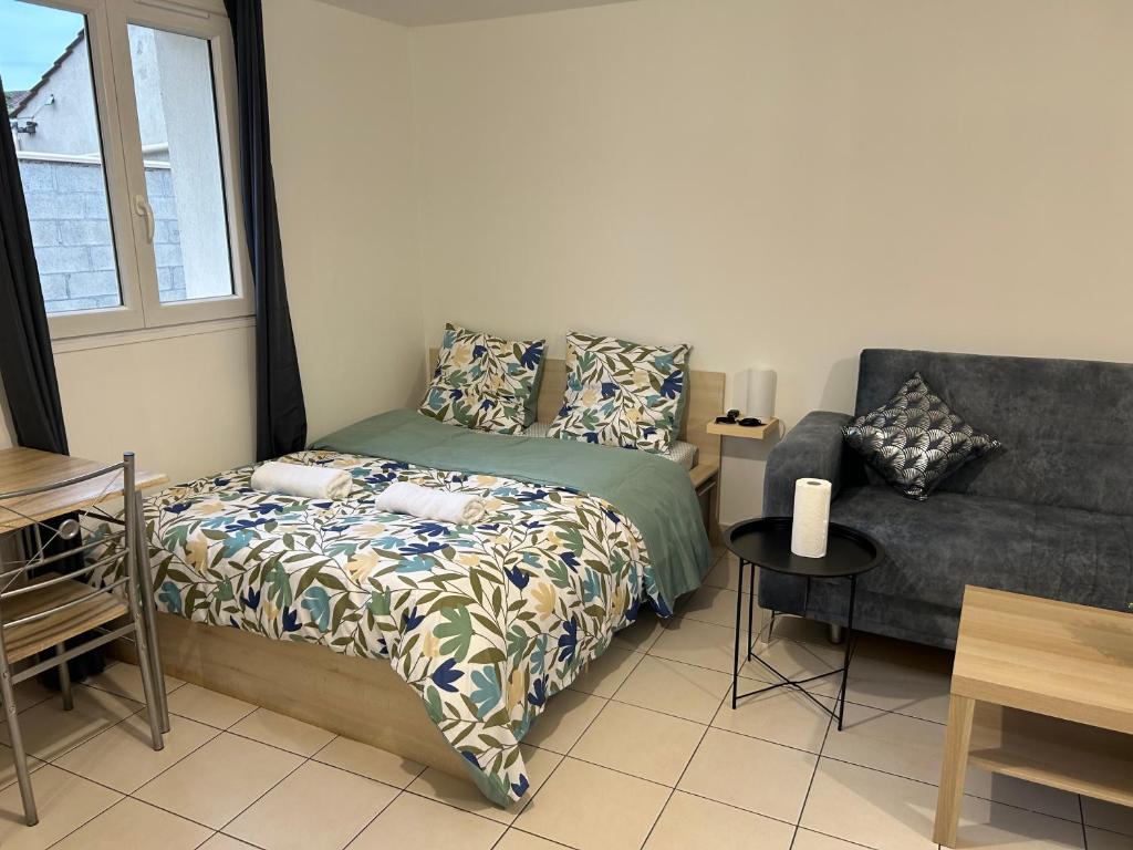 ein Schlafzimmer mit einem Bett und einem Sofa in der Unterkunft L'idéal séjour avec jardin privé proche Paris gare et commerce in Sarcelles
