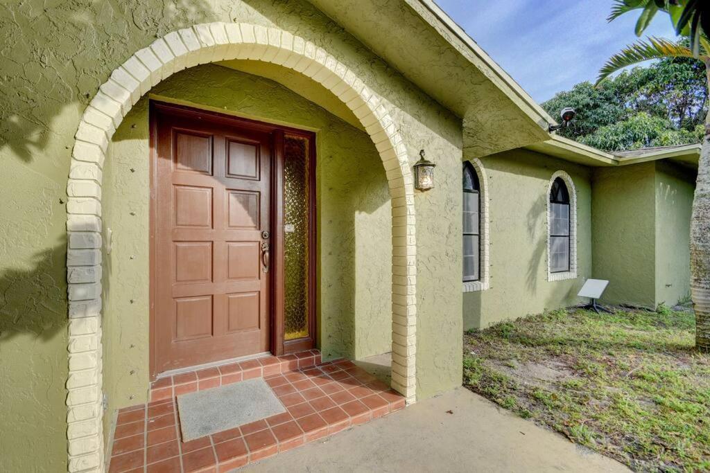 a house with a red door and an archway at Ananda Farmhouse and Retreat. in Lake Worth