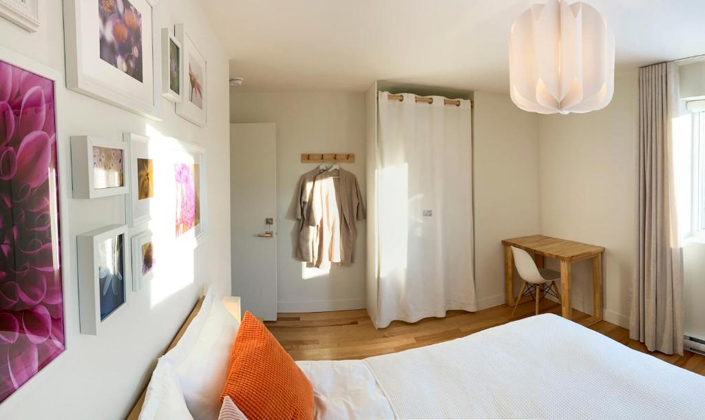 a bedroom with a bed and a table and a chandelier at Le Camp Caché Shefford in Shefford