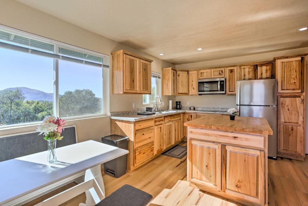 una cocina con armarios de madera y una gran ventana en Oakhurst Duplex about 13 Mi to Yosemite National Park!, en Oakhurst