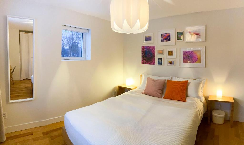 a bedroom with a large white bed with two lamps at Le Camp Caché Shefford in Shefford