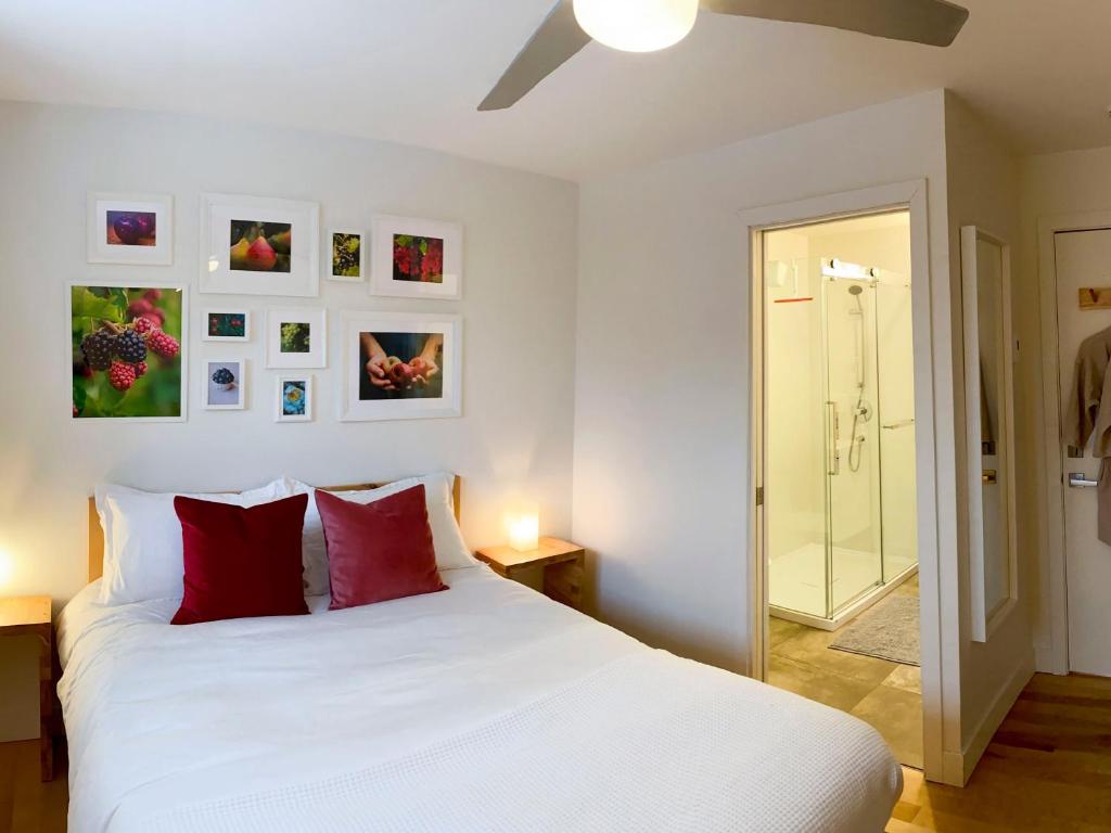 a bedroom with a white bed with red pillows at Le Camp Caché Shefford in Shefford