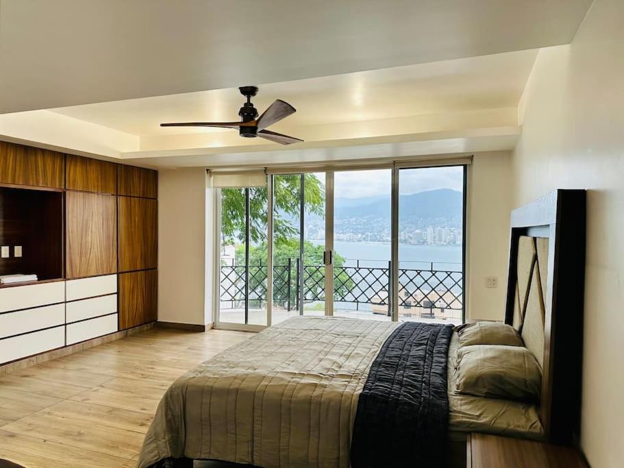 a bedroom with a bed and a view of the ocean at BRISAS GUITARRON in Acapulco