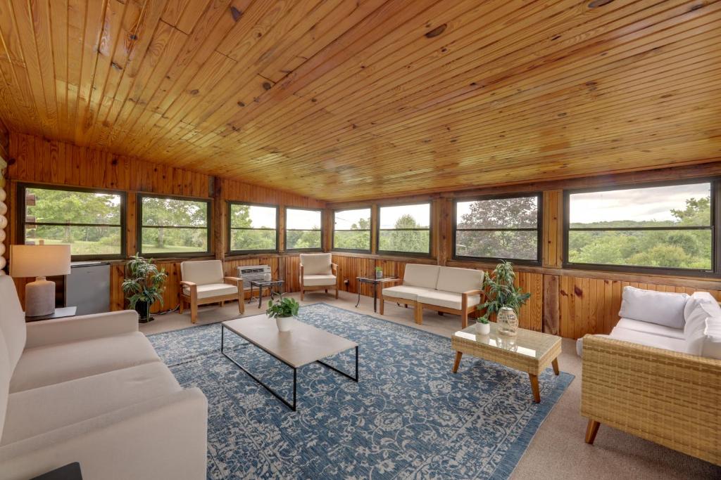 ein großes Wohnzimmer mit Holzdecken und Fenstern in der Unterkunft Cozy Brookville Home with Fire Pit and Deck! in Brookville