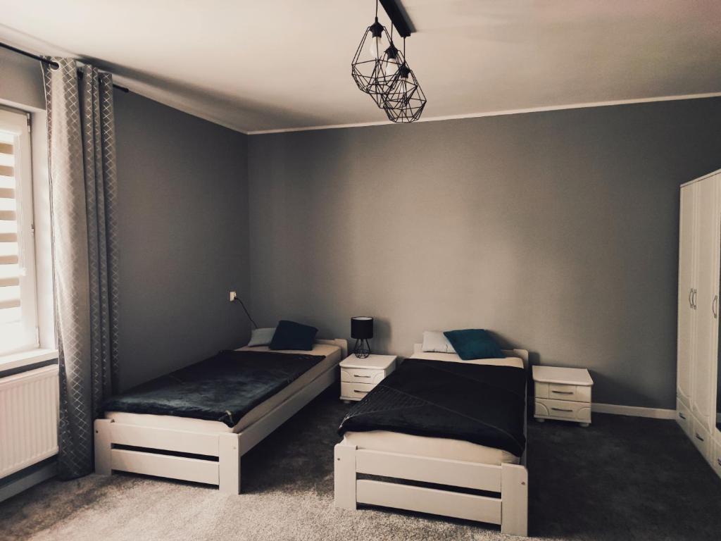 a bedroom with two beds and a wall at Samodzielne mieszkanie na parterze domu in Gardna Wielka
