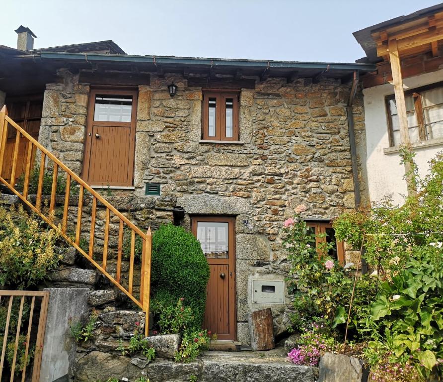 uma casa de pedra com uma porta de madeira e escadas em Toca do Esquilo - Montesinho em Montezinho