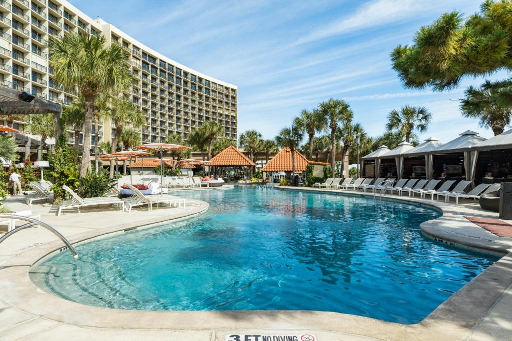 a swimming pool at the resort with chairs and a building at San Luis Ocean Oasis in Galveston