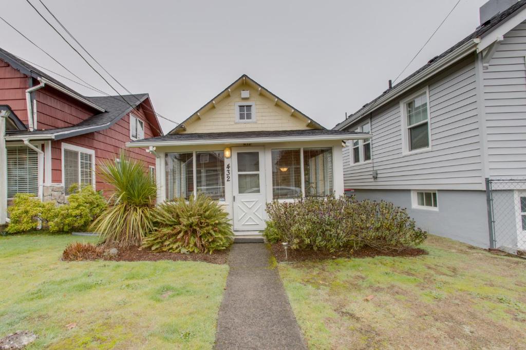 a house with a white door in a yard at The Sunfish in Seaside