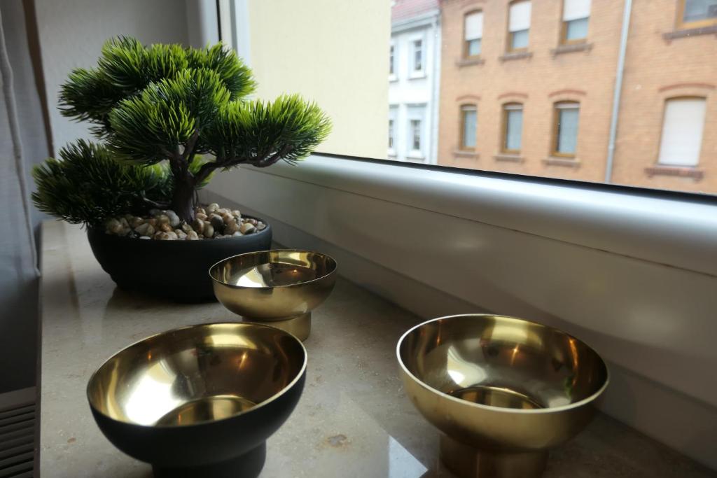 three gold bowls sitting next to a window with a tree at Ländlicher Rückzugsort im Herzen von Mühlhausen in Mühlhausen