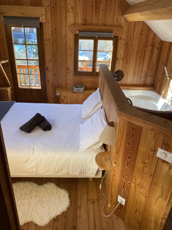 une chambre avec un lit et une baignoire dans l'établissement BEAU CHALET DE MONTAGNE SERRE CHEVALIER AU PIED DES PISTES PLEIN SUD, à La Salle Les Alpes