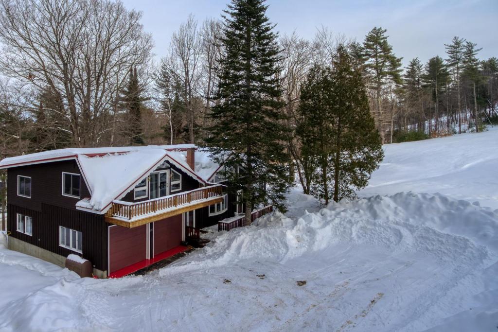 a house covered in snow with a pile of snow at Chalet at Shawnee in Bridgton