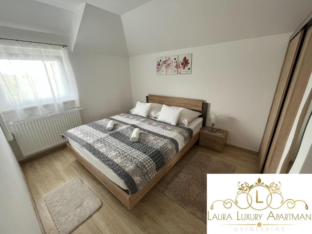 mała sypialnia z łóżkiem i oknem w obiekcie Laura Luxury Apartman Gyenesdiás w Gyenesdiás