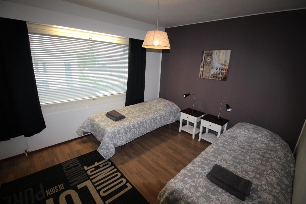ラーヘにあるMajoitusYkkönenのベッド2台、ソファ、窓が備わる客室です。