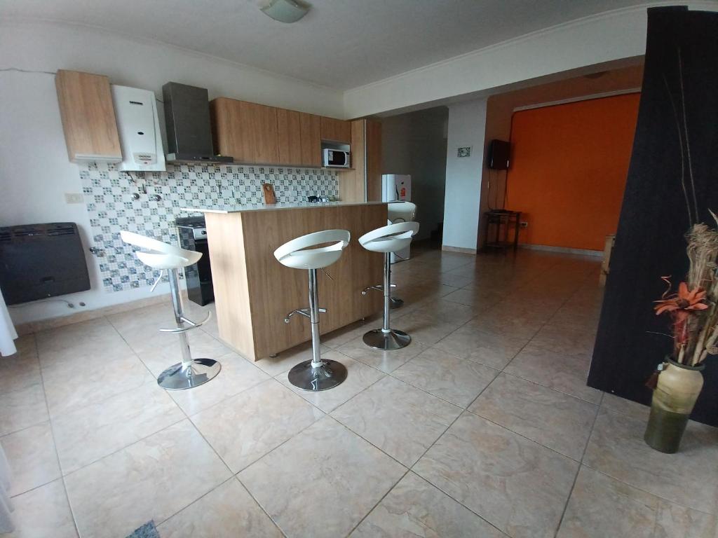 a kitchen with two stools in the middle of a room at Apartamento entero - Ushuaia, Tierra del Fuego in Ushuaia