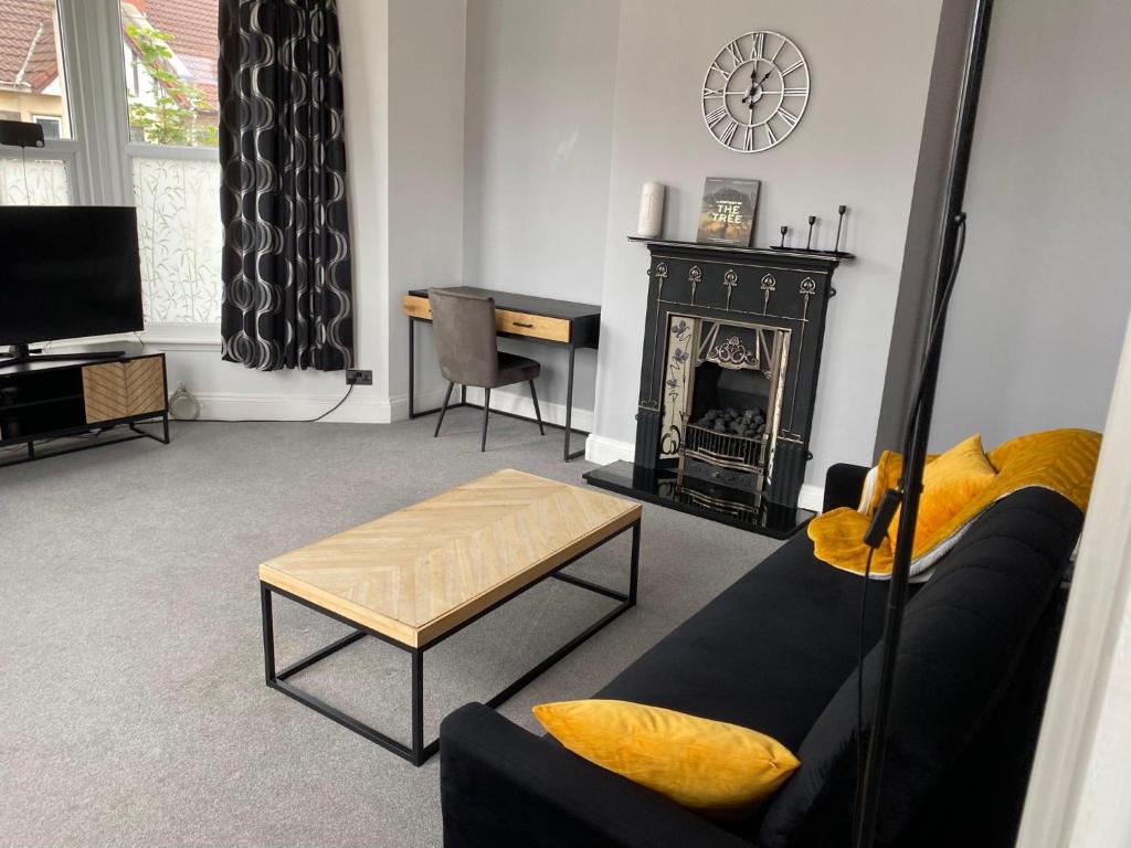 a living room with a couch and a fireplace at Stylish 91sqm Victoria 2 bedroom Apartment in Bristol