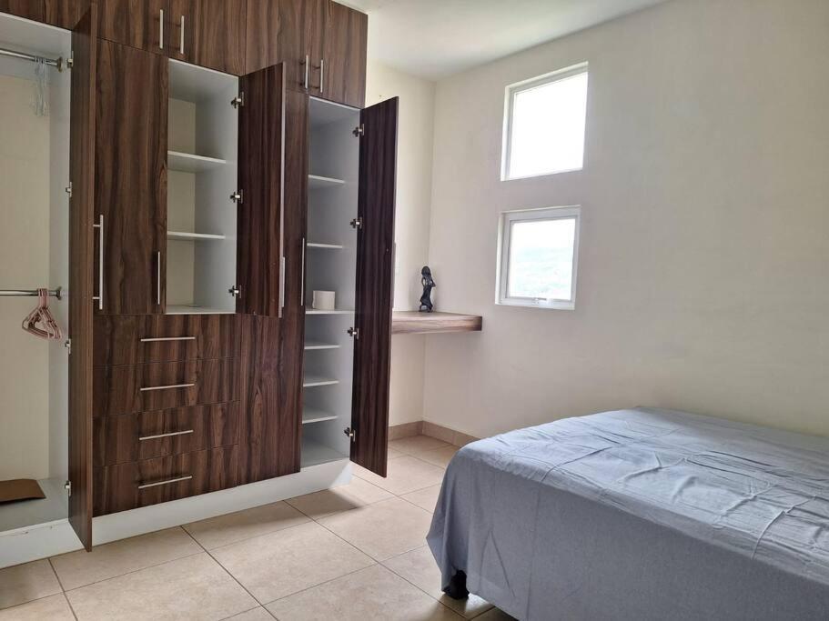 a bedroom with a bed and a wooden cabinet at departamento turístico en oaxaca in Oaxaca City