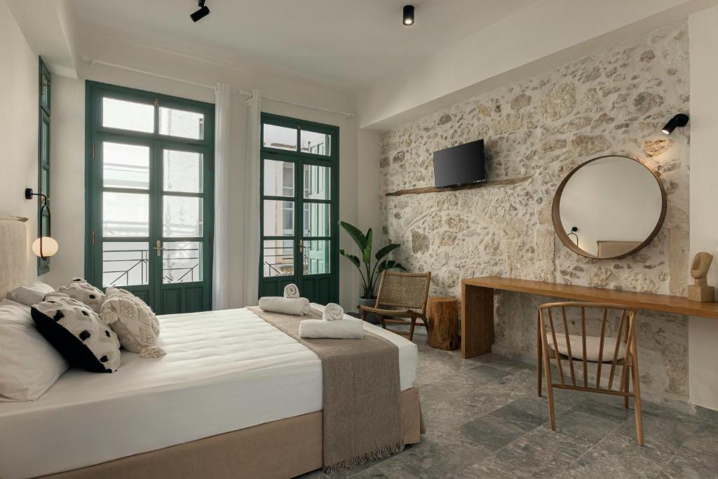 um quarto com uma cama grande e um espelho em Soleil boutique house with terrace em Retimno